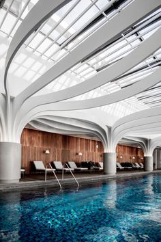 an indoor swimming pool with skylights above it