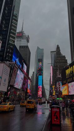 a city street filled with lots of traffic and tall buildings covered in billboards at night