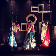 three different colored dresses on display in front of a mirror