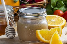 a jar filled with liquid next to sliced oranges