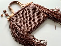 Introducing our crochet raffia bag in a rich chocolate hue, adorned with bamboo handles and finished with a trendy fringe for added charm. Fringe is all the rage right now, making this bag the perfect accessory to elevate your style. Elegant Brown Bags With Tassels, Luxury Brown Crochet Bag For Shopping, Elegant Brown Shoulder Bag With Tassels, Luxury Brown Handwoven Straw Bag, Luxury Brown Woven Straw Bag, Chic Straw Bag With Tassels, Luxury Brown Crochet Beach Bag, Brown Top Handle Crochet Bag In Straw, Brown Top Handle Crochet Straw Bag