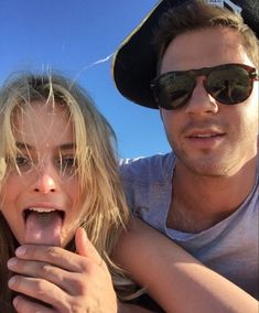 a man and woman taking a selfie with their tongue hanging out in front of the camera