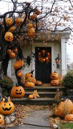 pumpkins are on the steps in front of a house decorated with jack - o'- lanterns