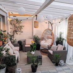 an outdoor living area with wicker furniture and hanging planters on the roof terrace