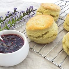 biscuits and jam on a cooling rack next to lavender sprigs with a spoon