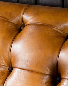 a brown leather couch with buttons on it