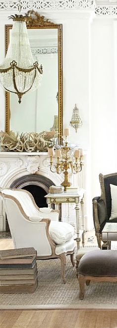 a living room filled with furniture and a large mirror on the wall over a fire place