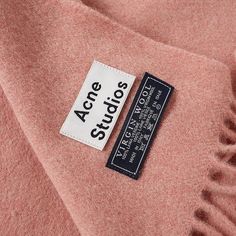 a label on a pink coat that says acne studios