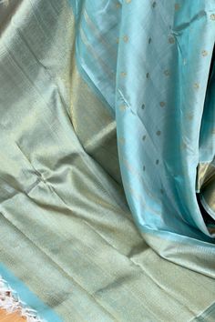 This exquisite kanjivaram saree in turquoise blue shot with ivory beige is handwoven with coin motifs in gold zari, on the body. The self bavangi borders have zigzag lattice motifs along with tiny paisely motifs in gold zari while the grand pallu features traditional motifs in gold zari. The blouse piece is in in the same color as the body of the saree. Approximate Length 6.5 mtrs (inclusive of blouse length)Height - 46 - 52" Approximate weight - 1.8 lbs Saree comes with fall, picot and tassels Festive Turquoise Silk Saree, Turquoise Silk Saree, Turquoise Kanchipuram Saree, Sky Blue Kanchipuram Saree, Gold Saree, Sea Green Kanchipuram Silk Saree, Blue Shots, Kanjivaram Saree, Kanjivaram Silk Saree