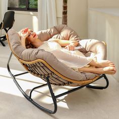 a woman laying in a chair with her eyes closed