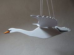 a white bird hanging from a string on the ceiling with two strings attached to it