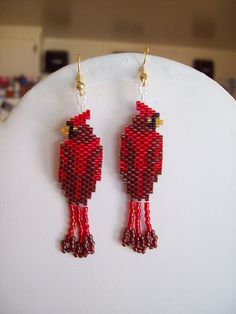 a pair of red beaded bird earrings