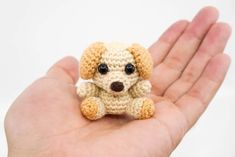 a small crocheted dog sitting in someone's hand