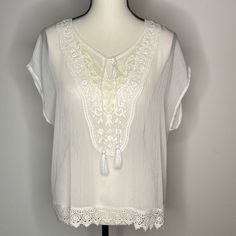 Ariat Sheer White Blouse Short Sleeve Light Weight Polyester Heavy Embroidered Detail At Front Bodice Split Neck Line With Cording Details Lace Trim Detail New - Never Worn Excellent Condition See Photos For Measurements And Details Measurements By Hand, May Vary Slightly White Embroidered Top With Summer Lace Work, Elegant Floral Embroidery Top For Vacation, White Embroidered Top With Lace Work For Summer, Elegant Floral Embroidered Top For Vacation, Beach Short Sleeve Blouse With Lace Trim, Casual White Blouse With Lace Work, Beach Blouse With Lace Trim And Short Sleeves, White Lace Tops For Vacation, Lace Short Sleeve Blouse For Beach