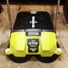 a yellow and black floor sweeper on the ground