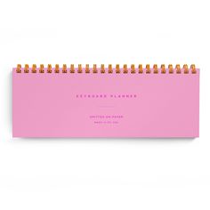 a pink notebook with gold writing on it