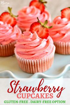 strawberry cupcakes with pink frosting and fresh strawberries on top, sitting on a white plate