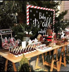 a table topped with lots of desserts next to a sign that says baby it's cold outside