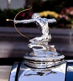 the hood ornament of a classic car with a man figure on it's head