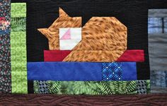 a cat is sitting on top of a patchwork table runner made with quilts