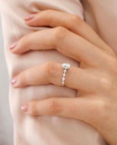 a woman's hand with a diamond ring on her finger