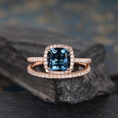 an engagement ring with a blue diamond surrounded by white and rose gold pave diamonds