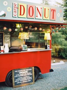 a food truck is parked on the side of the road and has donuts written on it