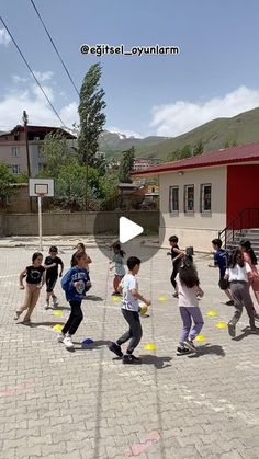 a group of children playing with frisbees in an open area next to a building