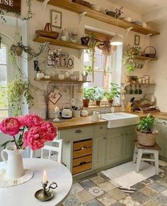 a kitchen filled with lots of counter top space and flowers on the shelves over the sink