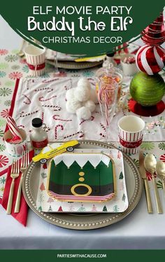 an elf movie party is set up on the table for christmas dinner with green and red decorations