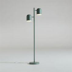 a green floor lamp with two lights on each side and one light on the other