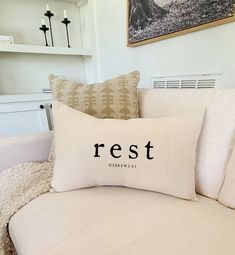 a white couch with pillows that say rest