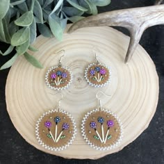 These beaded earrings are done on locally sourced moose hide. They have quill accents and hypoallergenic silver toned hooks. Available in 2 sizes. Light weight for comfortable wear. The outside beads are a pearlescent white! The colours are cool tones of blue, purple, pink, green and silver. White Beaded Earrings, Flat Stitch Beaded Earrings, Porcupine Beaded Earrings, Beaded Floral Earrings Native American, Porcupine Quill Earrings Native Americans, Beaded Earrings Native Beadwork Inspire Uplift ⭐, Inuit Beaded Earrings