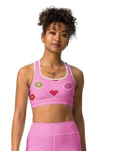 ABOUT Get ready to pucker up in this Valentine's Day-inspired sports bra! With a playful kiss print and comfortable fit, this bra will keep you supported and stylish during your workouts. Show off your fun and flirty side while staying active. (No puckering required!) Crafted with a breathable mesh fabric and unique cut-out design, this bra ensures maximum ventilation and comfort. The supportive straps and ribbed band provide added strength and stability, allowing you to reach your workout goals Playful Stretch Activewear For The Gym, Pink Athleisure Bra With Medium Bust Support, Playful Pink Activewear For Workout, Trendy Workout Fitted Bra, Trendy Fitted Workout Bra, Pink Racerback Sports Bra With Medium Bust Support, Pink Racerback Bra For Yoga, Pink Racerback Yoga Bra, Playful Pink Fitted Activewear