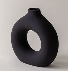 a black vase sitting on top of a white table