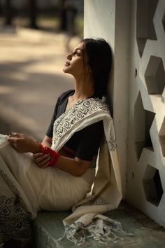 a woman sitting on the side of a building