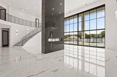 an empty room with marble flooring and stairs leading up to the second story window