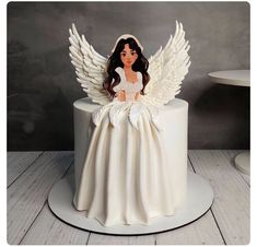 a cake with an angel figurine sitting on top of it