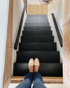 someone's feet on the stairs in front of a chandelier and light fixture