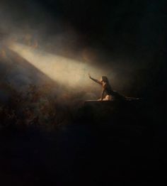 a woman sitting on top of a surfboard under a bright light in the dark