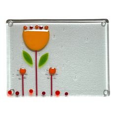 an orange flower with green leaves and red berries on it is mounted to a glass plate