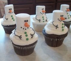 cupcakes made to look like snowmen with frosting on them