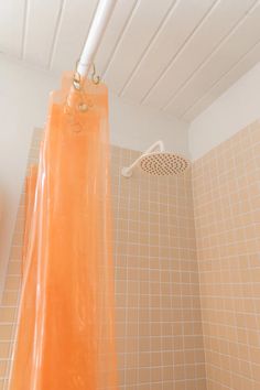 an orange shower curtain hanging from the ceiling