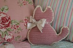 a crocheted cat pillow sitting on top of a bed