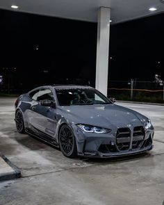 a grey car parked in a parking lot at night