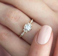 a woman's hand with a ring on it and a manicured nail polish