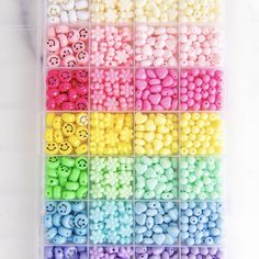 a box filled with lots of different colored candies next to each other on top of a white surface