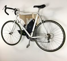 a white bicycle hanging on the wall