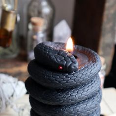 a stack of black tires with a lit candle in the middle, on top of a table