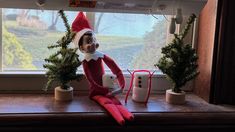 an elf is sitting on the window sill